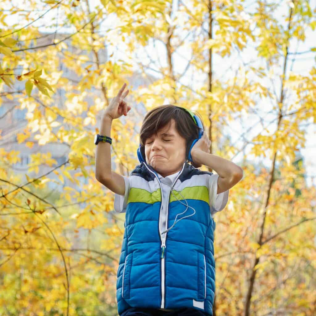 Little boy with headphones with trees with yellow leaves on background - Promote indie games marketing jeux vidéo